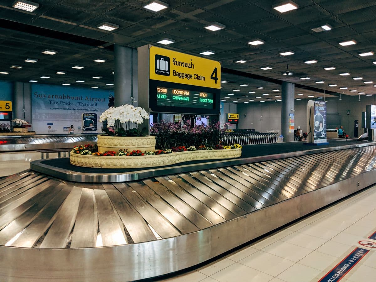An empty baggage claim carousel in an airport arrivals hall