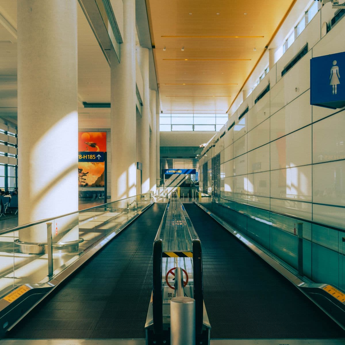 Empty moving walkway in a sunlit airport terminal